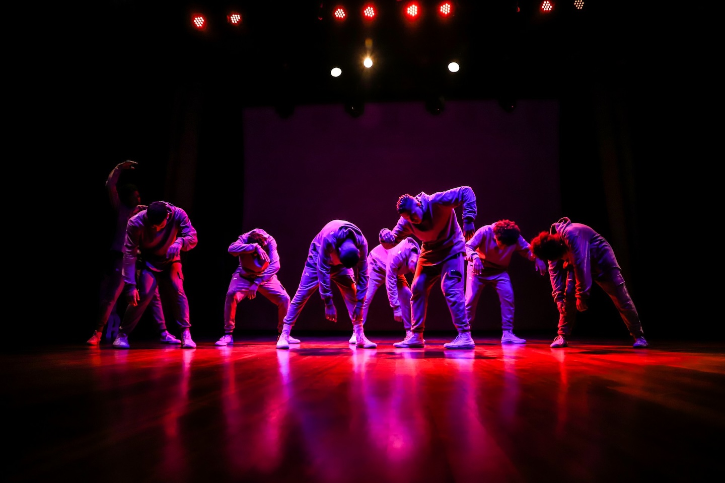 An all-male hip-hop group performs a dance.