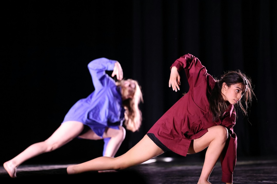 Two teenage girls perform a contemporary dance.
